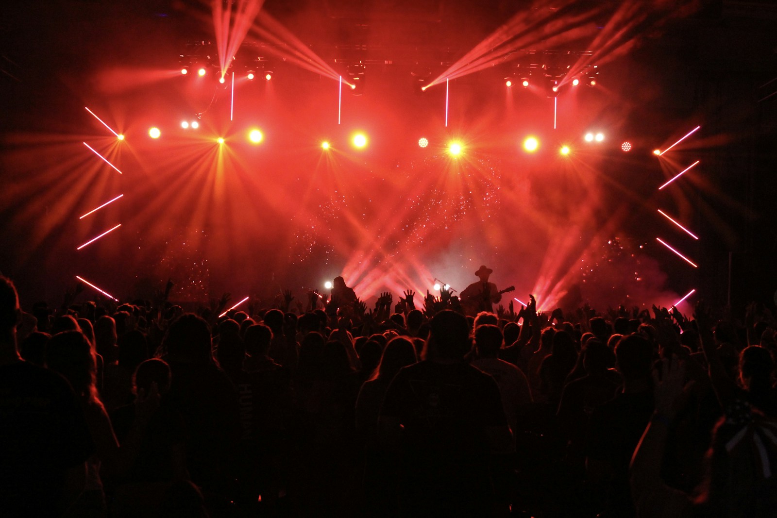 A crowd beneath dramatic red concert lighting